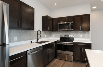 A kitchen with dark wood cabinets and stainless steel appliances